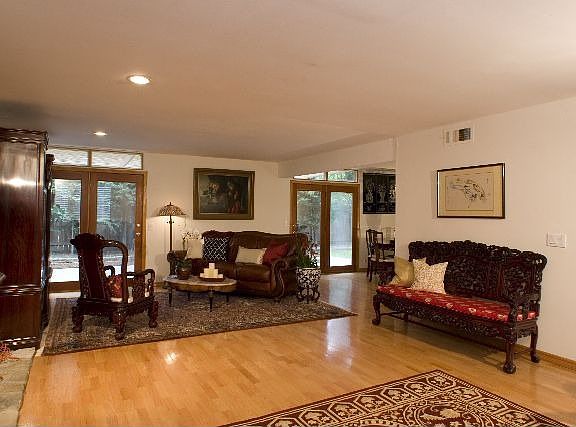 Living room with gorgeous hardwood floors, french doors and open to the dining