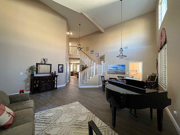 Front entry, living room & dining room with vaulted ceilings. Baby grand piano.