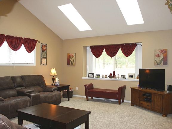 The living room is light and spacious, with skylights, cathedral ceilings, and new carpet!