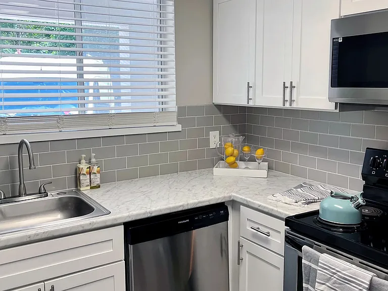 Renovated kitchen options include modern finishes with white cabinetry and subway tile backsplash for a chic living experience.