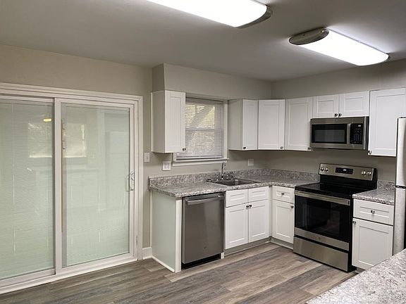 Brand new lighting, appliances, island and kitchen window overlooks the back yard.