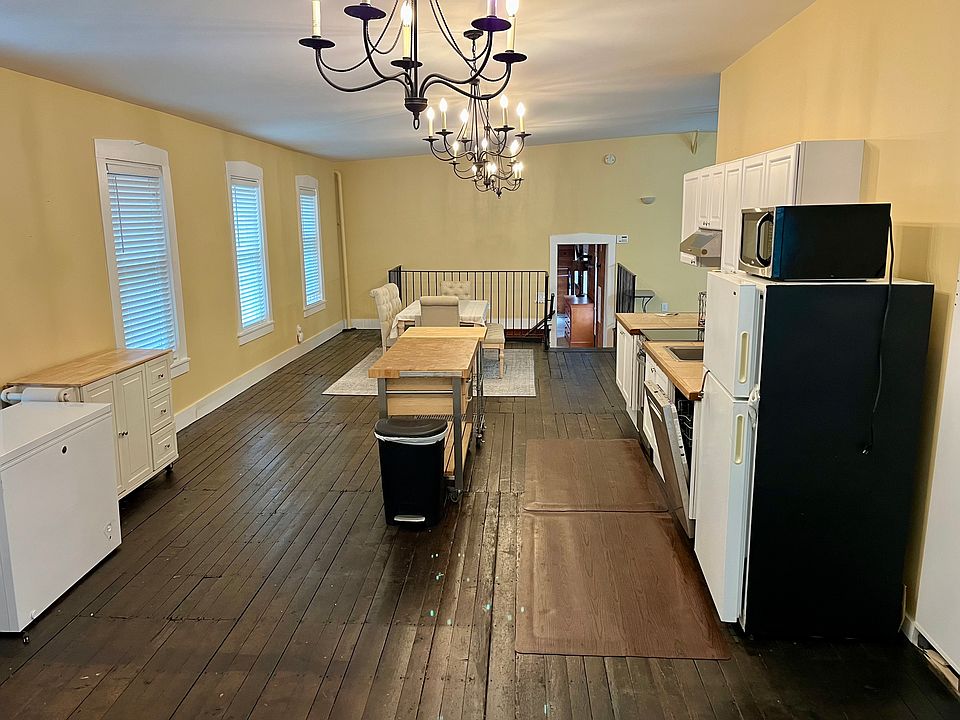 Kitchen area (View from opposite end of the stairwell. Fridge, microwave, kitchen counter, sink, stove/4 electric range unit, hood, Bosch dishwasher, cabinets on the right, both islands included, box freezer is not. The open door is the bedroom area)