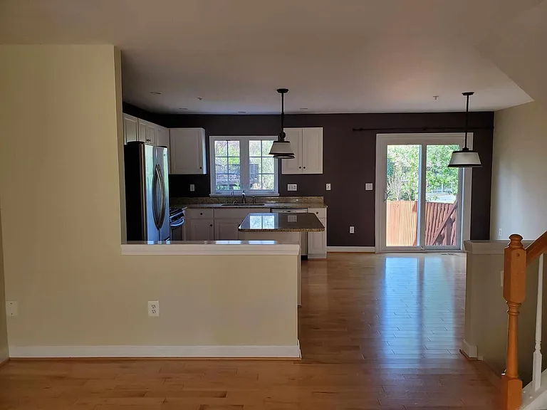 view from living room to kitchen. Light fixtures in dining and kitchen have been updated and no longer this black color