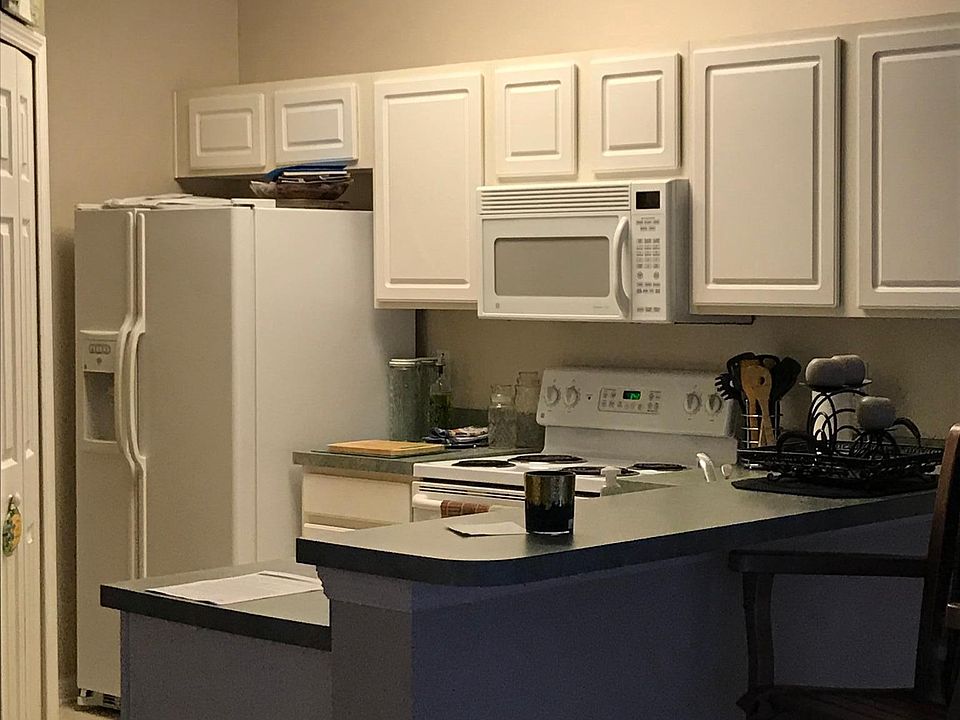 All white kitchen opens into living room/dinning area. Spaci
