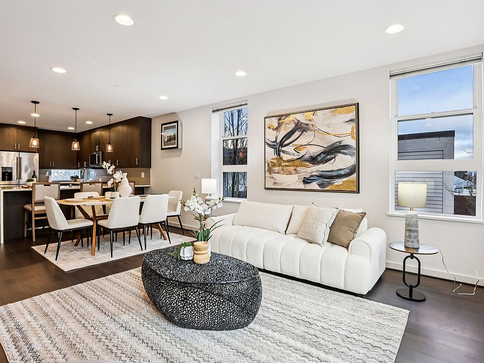 Modern townhome with chef's kitchen, sun-filled spaces, open railings, and hardwood floors.