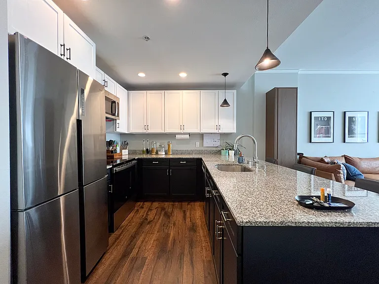 Full kitchen furnished with Calphalon cookware, granite countertops, stainless steel appliances including a dishwasher.