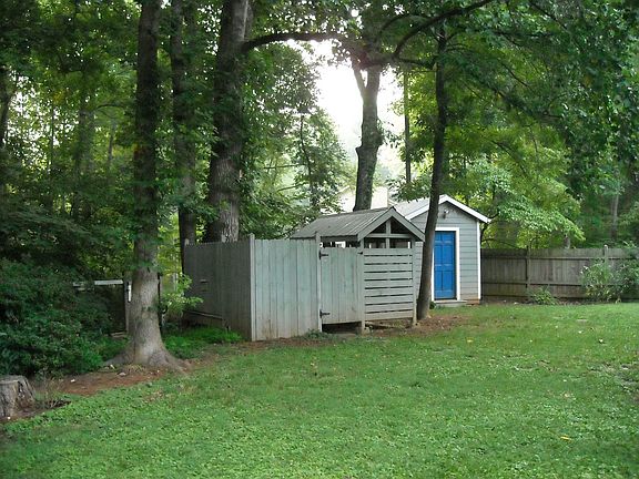 Yard view with garden shed and enclosed spa
