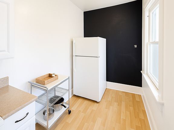 Second kitchen angle showing refrigerator and additional storage.
