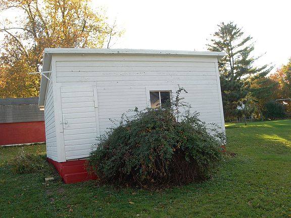 White shed behind the house