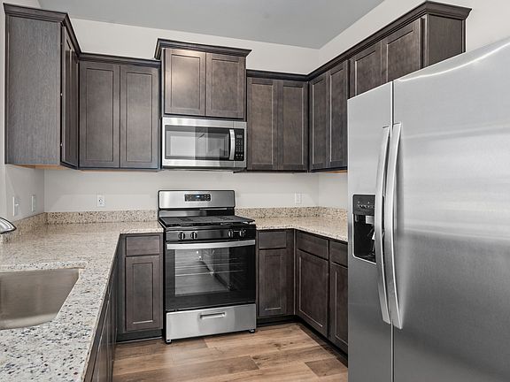 The kitchen has designer wood cabinetry.