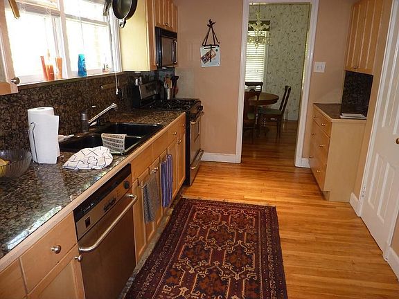 Updated kitchen has newer cabinets, gas range, granite tile countertops. All appliances including re