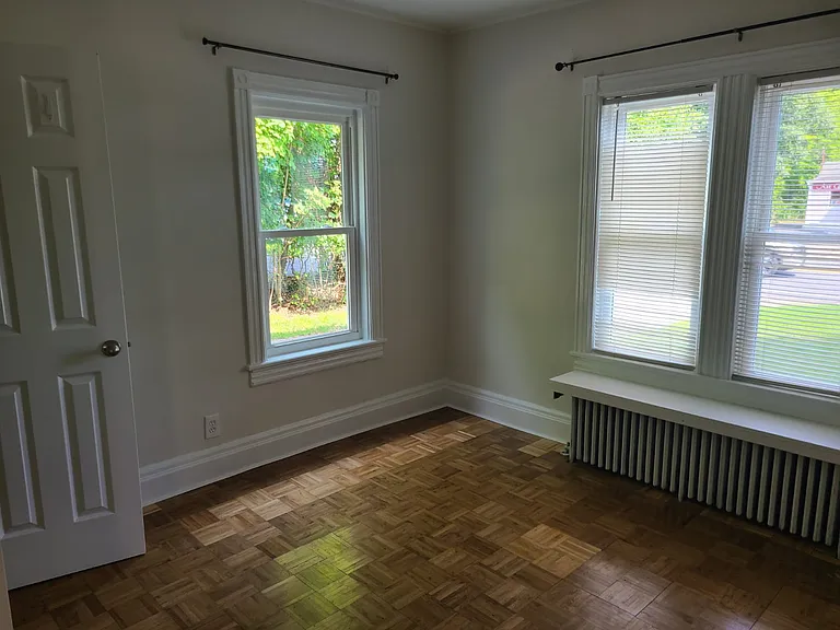 First bedroom has plentyt of light with parquet wood floors.