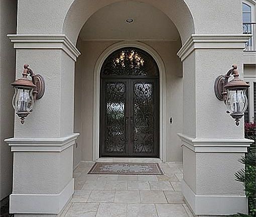 Grand entry with stone  & custom wrought iron double doors!