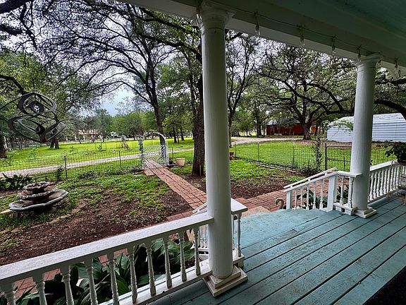 Porch, fenced front yard and fountain
