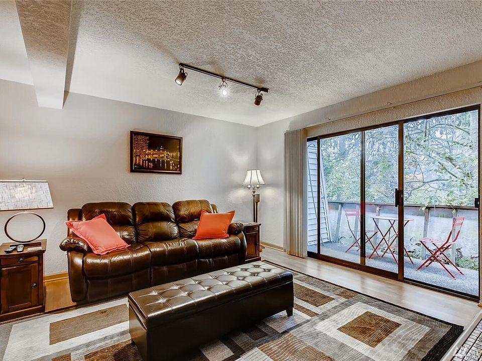 Large open living room with private deck under canopy of trees.  Deck to be completely re-done beginning Spring of 2021.  Don't miss the new look on the already completed front building decks!