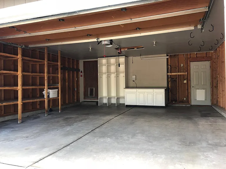 HUGE garage with storage shelves, cabinets and backpack/coat built-ins.