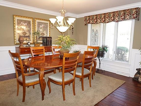 Formal dinning room is located off the entry that is also updated with the new wood flooring.  Custom moldings including crown, chair rail and shadow boxing enhance the richness of this formal space.