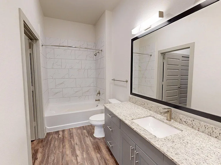 Apartment Bathroom with large soaking tub and Wood Style Flooring.