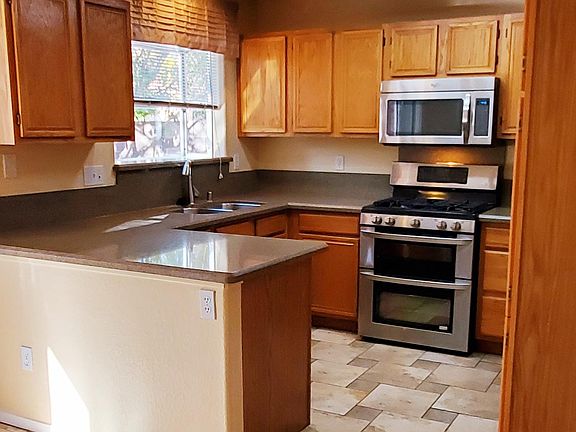 Upgraded kitchen with stainless steel appliances and extended greenhouse window with shelf for plants