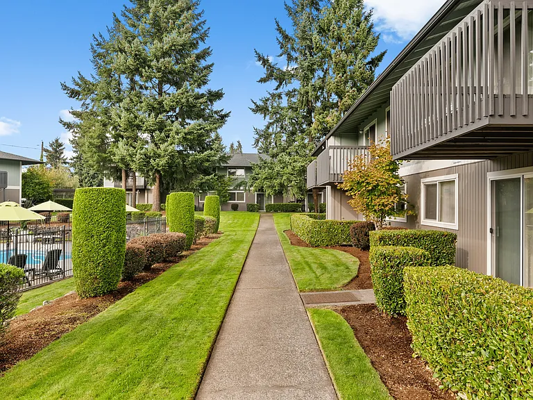 Peaceful walkways lined with greenery and poolside views.