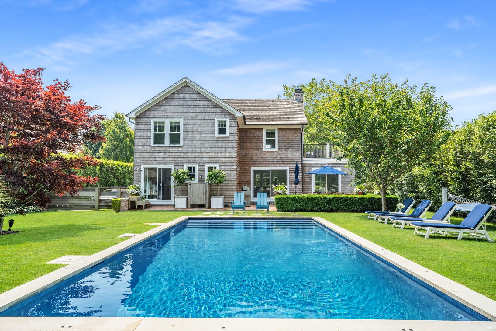 Landscaped backyard with heated pool and outdoor shower
