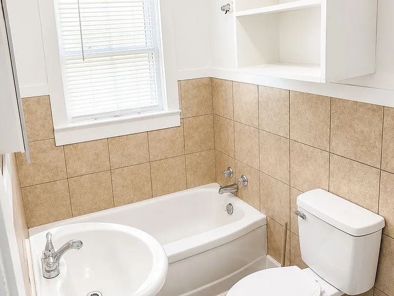 Full Bathroom with tub/shower combination and additional storage cabinet.