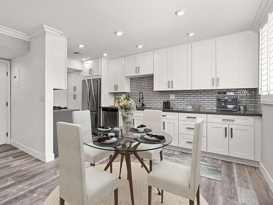 Hardwood floored dining room with view of gorgeous tiled kitchen.
