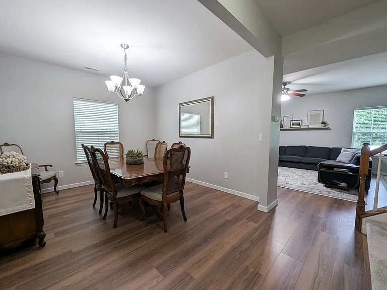 Entry hallway at bottom of stairs showing dining room and family room