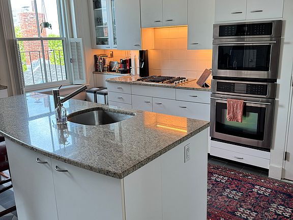 Cook's kitchen with granite island, wall oven and microwave, down draft cooktop