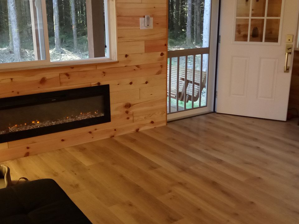 Living area and entry door off covered porch with swing. Large fully programable electric fireplace for heat and atmosphere.