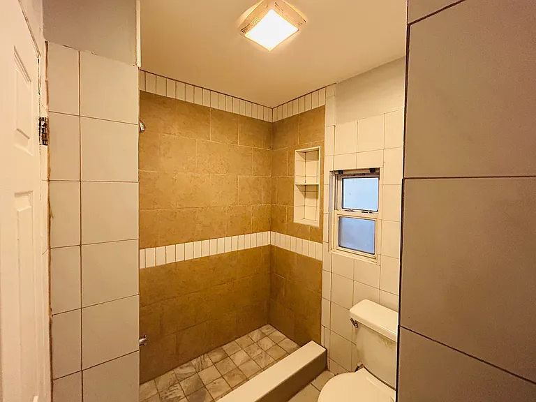 Bathroom with new shower, new ceiling, and re-finished wall and floor tiles. Have bathroom vent and window.