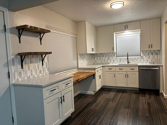 Features 42"H upper cabinets, quartzite counters, built-in desk-height butcher block counter
