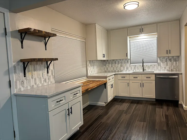 Features 42"H upper cabinets, quartzite counters, built-in desk-height butcher block counter