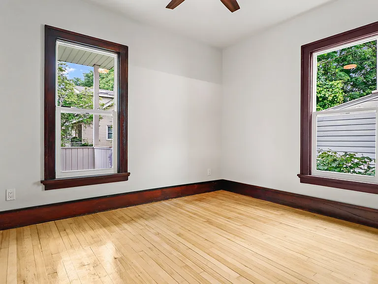 Back bedroom from doorway. See those floors shine! All new windows! Ceiling fans pretty and practical addition!