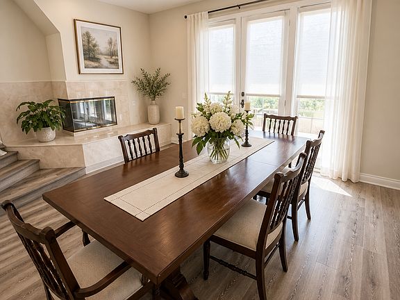 Dining Room - Bathed in natural light, this inviting dining room offers a warm and welcoming space perfect for everyday living or entertaining. Large windows and French doors fill the room with sunshine and open to the generous patio.