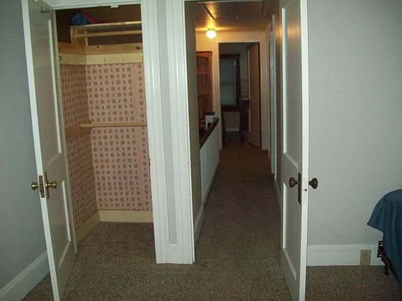 master bedroom with closet looking down hallway between bedrooms