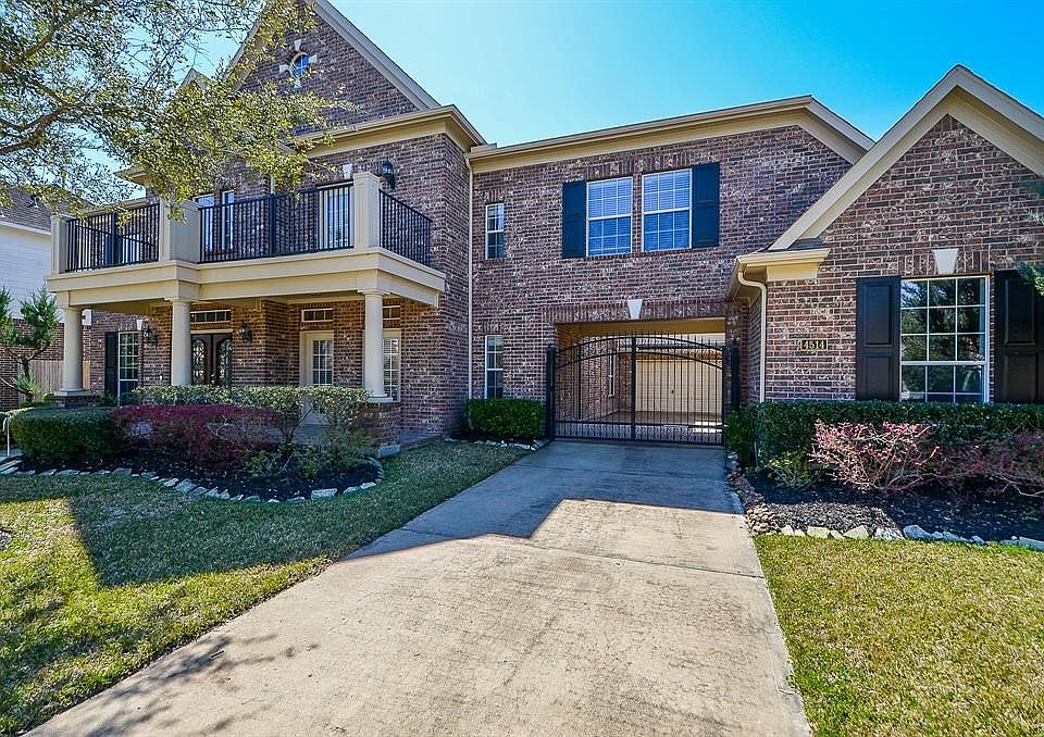 This beautiful Taylor Woodrow home is inviting with a front balcony, covered porch and an auto court with wrought iron gate. Lus