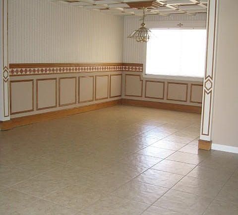 The dining room has a chair rail and faux tin roof