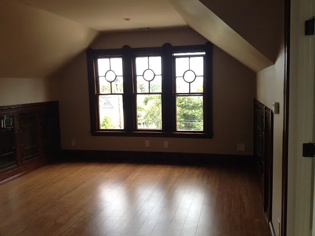 Living room with original windows looking toward Oakland with built in bookshelves with leaded glass