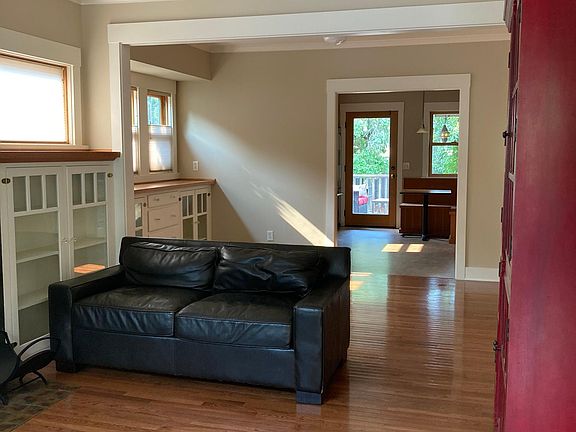 view of living/dining room, into kitchen (red bookcase and sofas included)