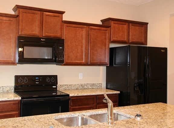 Another view of the kitchen from the dining area. Delta faucet, granite countertops, side by side r