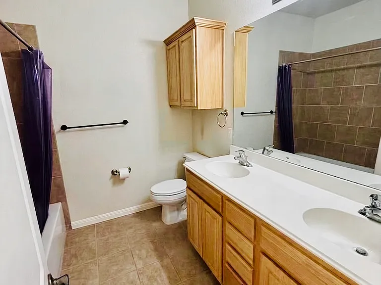 Full secondary bathroom with tub/shower combo, single vanity, and tile flooring throughout
