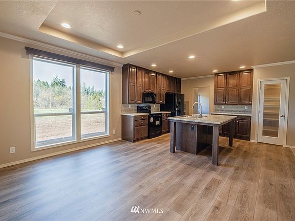 Dining room with coffered ceiling. Large kitchen with tall cabinets, breakfast bar kitchen island and large walk-in pantry. 