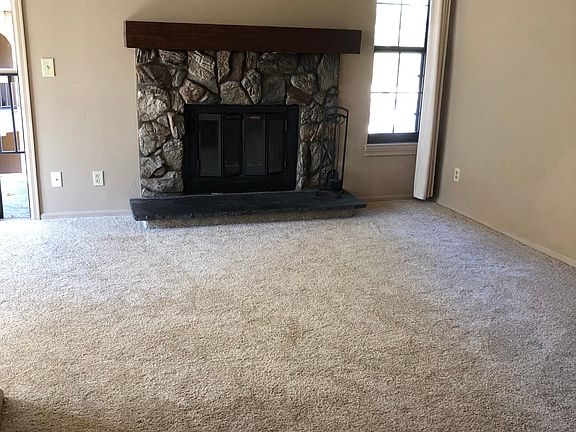 Entering unit. Wood-burning fireplace. Living room. Dining area, kitchen and balcony to left.