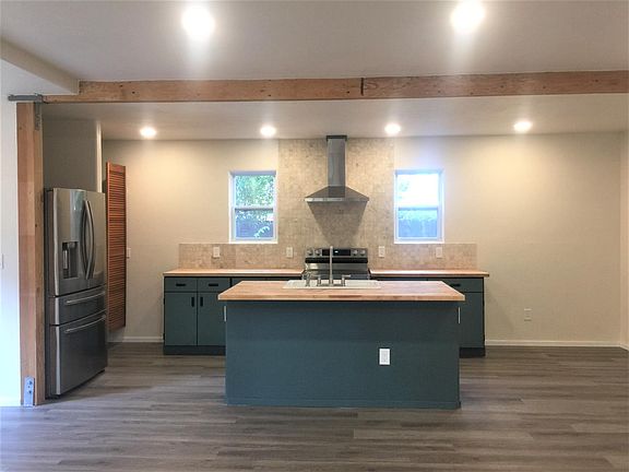 Reclaimed vinyl cabinets, stainless steel appliances, 8' ceilings with exposed beams, butcher block countertops.