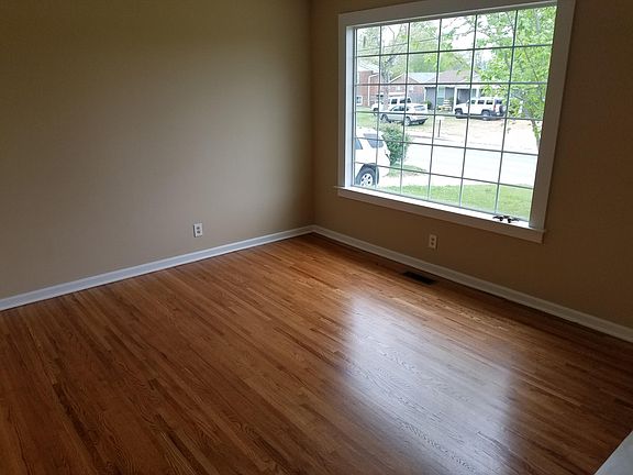Living room with large window and newly refinished hardwood floors