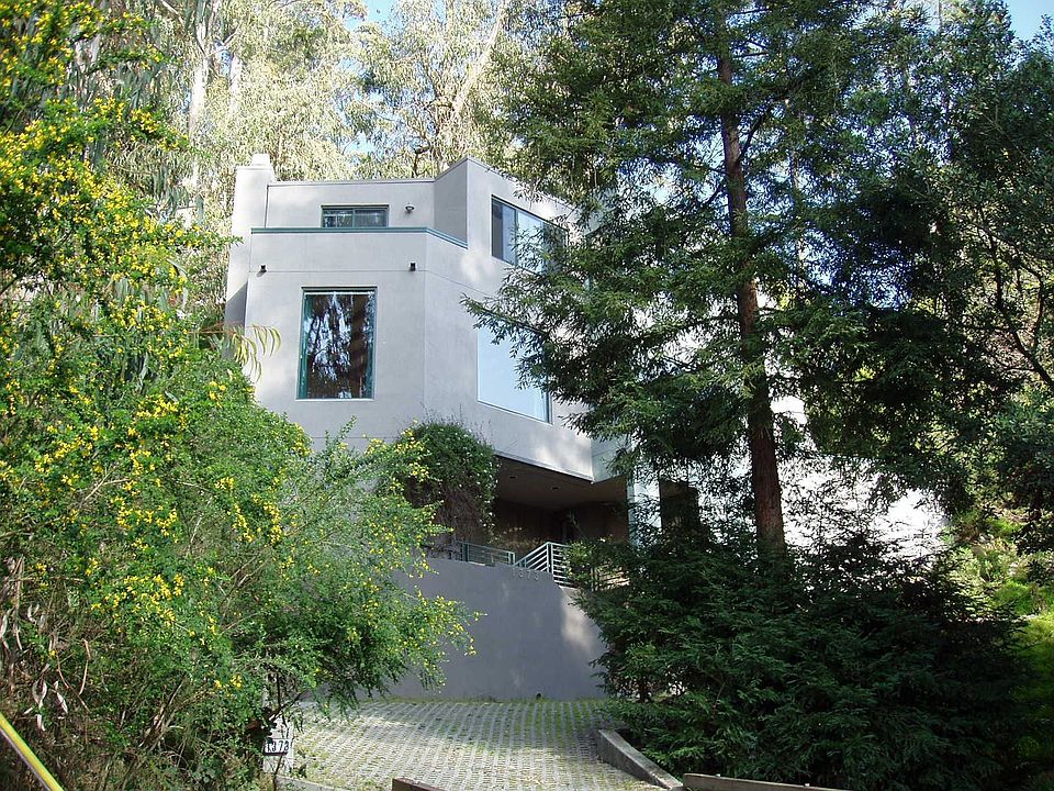 Elegant light-filled residence in a serene wooded setting w/seasonal creek! 