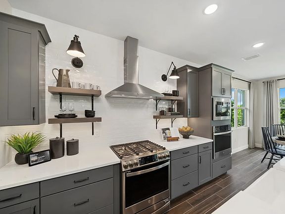 Kitchen with floating shelves and white tile backsplash