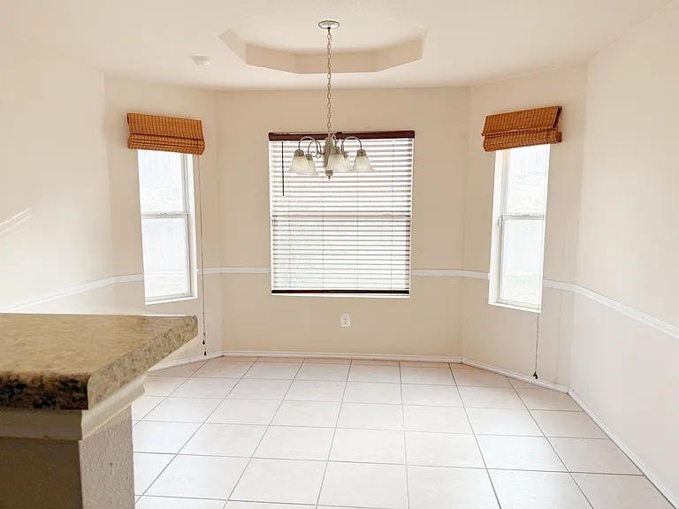 Wonderful dinette with lovely bay windows and a chandelier in the framed ceiling.