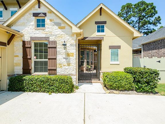 Stone, stucco, and brick elevation with gated courtyard entrance reminiscent of a beautiful Tuscan villa.